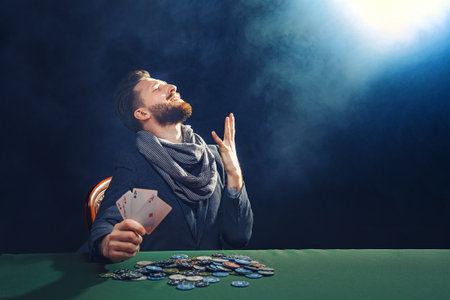 Happy poker player winning and holding a pair of aces.の写真素材