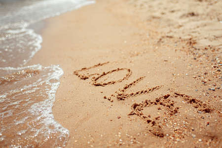Handwritten Love Word on the Sand Coast. Wonderful words on beach sand. Love idea concept.の写真素材