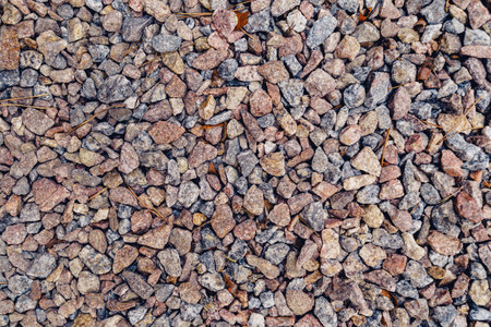 Background of natural grey granite crushed stone, macadam. Macro photo of texture of broken stone or...