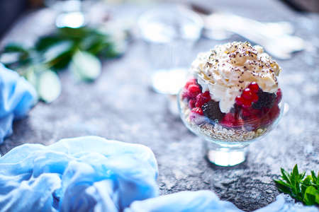 Recipe ideas for summer diet breakfast, healthy morning dessert in portioned jars with summer berries - raspberry, cherries, blackberry. On stone background.の写真素材
