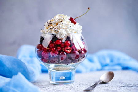 Recipe ideas for summer diet breakfast, healthy morning dessert in portioned jars with summer berries - raspberry, cherries, blackberry. On stone background.の写真素材