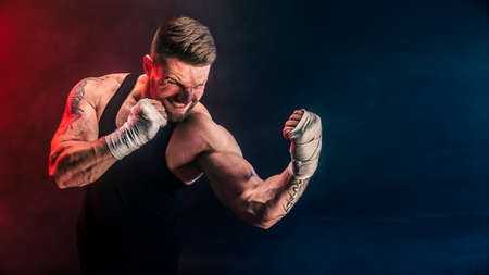 Sportsman muay thai boxer fighting on black background with smoke. Sport concept.の写真素材