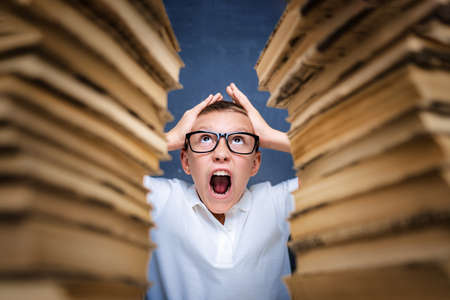 Young boy in stress getting crazy while studying and doing homework in children education concept...