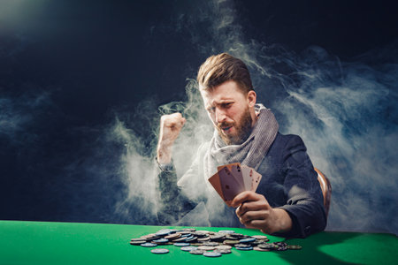 Happy poker player winning and holding a pair of acesの写真素材