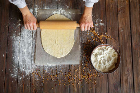 Womans hands roll out the dough