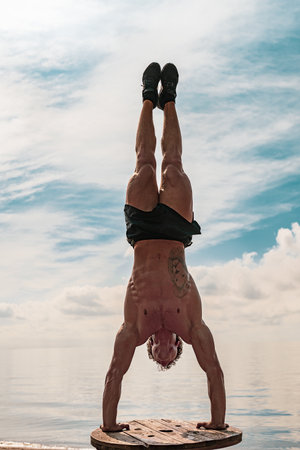 Young man is doing street workout. Handstand exercise, bodyweightの写真素材