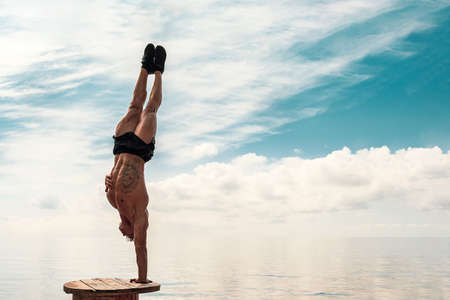 Young man is doing street workout. Handstand exercise, bodyweightの写真素材