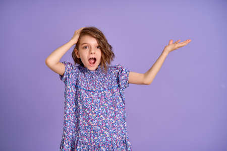 Photo of nice amazed little girl isolated on lavender, purple color background.の写真素材