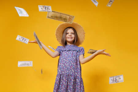 attractive european girl throws money in hands on a yellow background.の写真素材