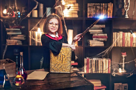 Small wizard holds magic wand and book Cosplay  Halloween holiday Halloween decorationsの写真素材