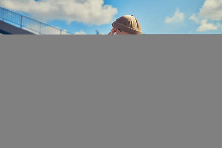 Concentrated bearded man sitting in outdoors and typing text on laptop. 4G internet connectionの写真素材