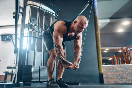 Brutal bodybuilder works out trains in the gym gains weight pumping up muscles. Bodybuilding conceptの写真素材