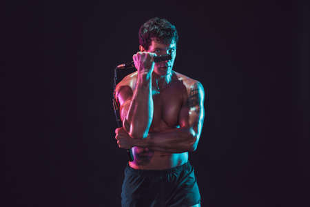 Half length of man who trains with nunchaku while isolated on black background. Sport conceptの写真素材