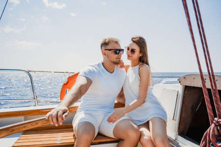 Young couple have romantic walk on the yacht and relaxing. Weekend at sea. Travel concept. Honeymoonの写真素材