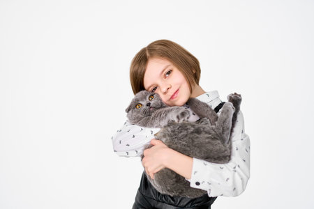 Caucasian little girl holds her cat in the armsの写真素材