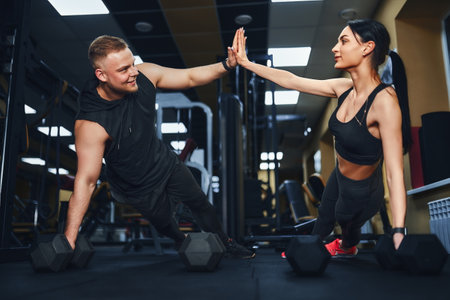 Strong and Beautiful Athletic Fitness Couple in Workout Clothes Doing Push Up Exercises and Giving...