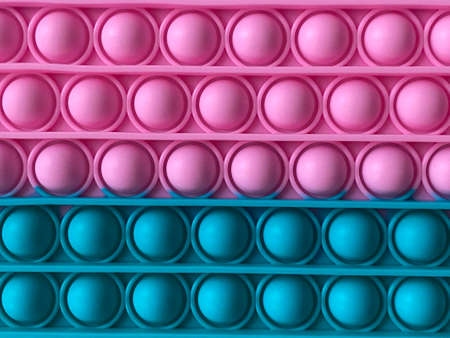 Trendy popular silicone colorful anti stress pop it toy . Close up. Someone push sensory popit....