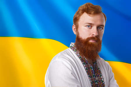 Man in vyshyvanka with flag of Ukraine backgroundの写真素材