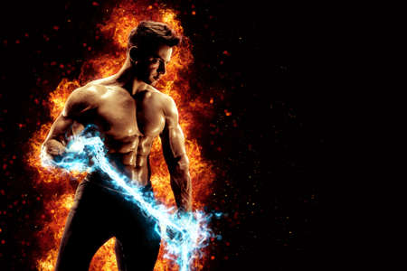 Muscular man with naked torso holding electric energy chain. Isolated on dark background with fireの写真素材