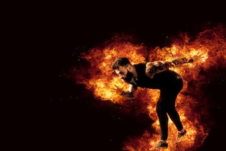 Sporty young man running on fire backgroundの写真素材