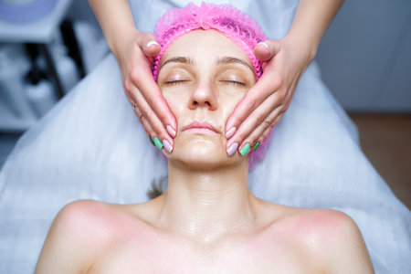 Cosmetologist applies cream on the skin of the clientの写真素材