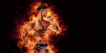 Bodybuilder posing on the fire flames backgroundの写真素材