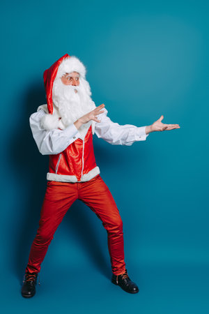 Full size of stylish santa claus who gesturing hands pointing to ad text. New Year advertisementの写真素材
