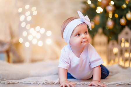 Adorable little girl playing with ornaments under decorated Christmas tree