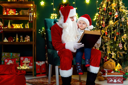 Santa Clause reads a book to a little boy while sitting near Christmas tree. New Year concept