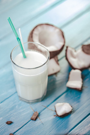 Top view of coconut cocktail in glass with coconut on white wooden table. Selective focus. Tropicalの写真素材