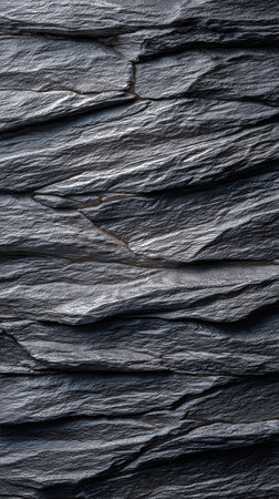 Dark slate stone surface with layered texture and rich details. Unique natural patterns create visual interest. Concept of architecture, interior design, landscaping.の素材