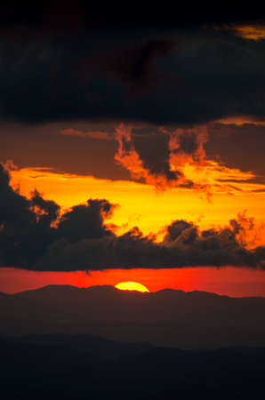 sunset behind black cloud with orange skyの写真素材