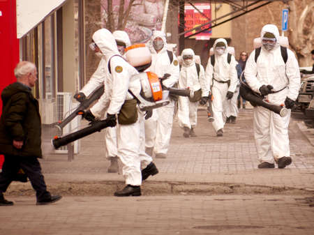 Karaganda, Kazakhstan - 3nd April, 2020 - Meticulous disinfection and decontamination on the streets as a prevention against Coronavirus disease (SARS-Cov-2), COVID-19 outbreak. soldiers in white overallsのeditorial素材