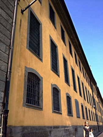 A woman walking alongside an old buildingの素材