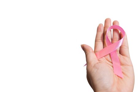 Pink ribbon for breast cancer awareness on people living with women's breast tumor illness. Woman holding pink ribbon on white background. Cancer awareness concept.の写真素材