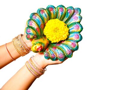 Happy Diwali - Woman hands with henna holding lit candle isolated on white background. Hindu festival of lights celebration. Copy space for text.の写真素材
