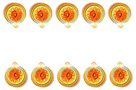 Happy Diwali - Clay Diya lamps lit during Dipavali, Hindu festival of lights celebration. Colorful traditional oil lamp diya on white background. Copy space for text.の写真素材