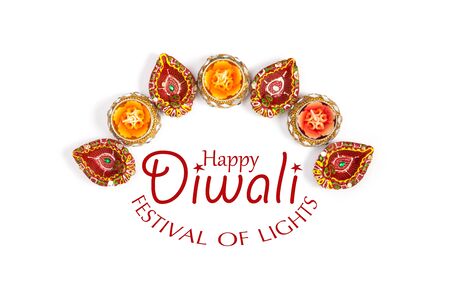 Happy Diwali - Clay Diya lamps lit during Diwali, Hindu festival of lights celebration. Colorful traditional oil lamp diya on white background. Copy space for text.の写真素材