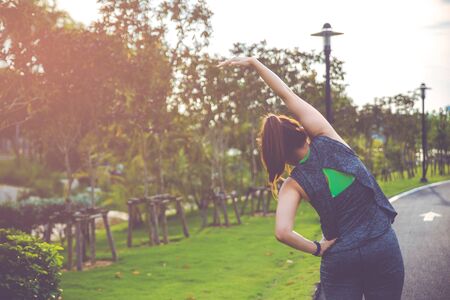 Women exercising. Young fitness woman exercising in the morning at the public park.の写真素材