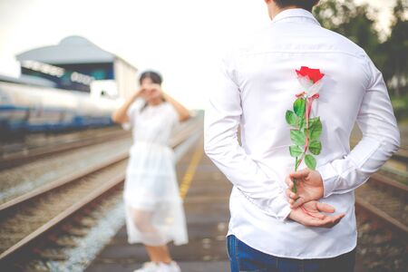 Loving couple. Man with rose waiting his woman on the railway. The romantic date or wedding or valentines day concept.の写真素材