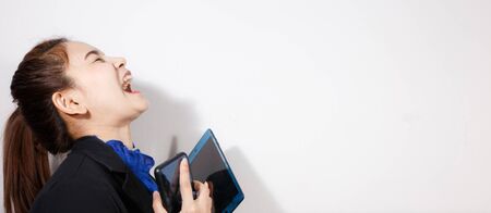 Laughing business woman wearing blue shirt and suit holding smartphone on white background. Business concepts. Copy space for text.の写真素材