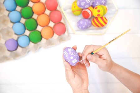 Human hands painting Easter eggs. Colorful handmade easter eggs isolated on a white background....