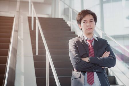 Business man portrait at the office. Casual young businessman wearing white shirt with red and black suit.の写真素材