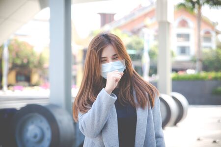 Virus mask Asian woman travel wearing face protection in prevention for coronavirus. Sick woman in public space bus station or airport. Air pollution, Coronavirus pandemic, environmental concept.の写真素材