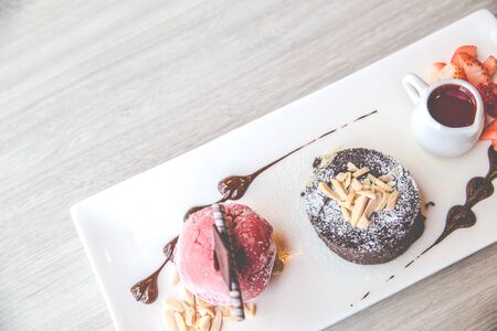Top viewof the chocolate lava dessert with strawberry ice cream and strawberry jam on a white plate. Copy space for text.の写真素材