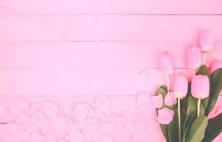 Beautiful tulips on pink background, top view, frame, border. Lovely greeting card with tulips for Mothers day, wedding or happy event concepts. Copy space for text.の写真素材