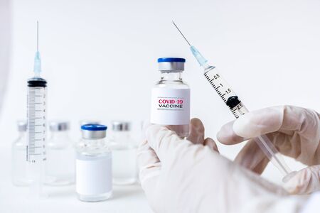 Development and creation of a coronavirus vaccine COVID-19. Coronavirus Vaccine concept in hand of doctor white vaccine jar and syringe. Vaccine Concept of fight against coronavirus. Healthcare And Medical concept.の写真素材
