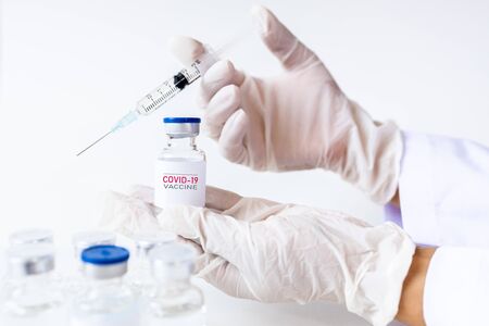 Development and creation of a coronavirus vaccine COVID-19. Coronavirus Vaccine concept in hand of doctor white vaccine jar and syringe. Vaccine Concept of fight against coronavirus. Healthcare And Medical concept.の写真素材