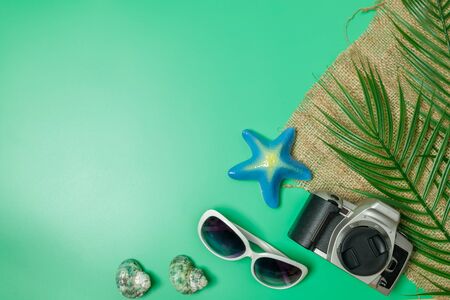 The beach accessories on the green background. Summer is coming concept. vacation and travel concept. copy space.の写真素材