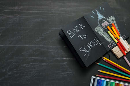 School supplies on black board background. Back to school concept.の写真素材